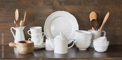 Fotografia Crockery, clayware, white utensils and other different stuff on wooden tabletop