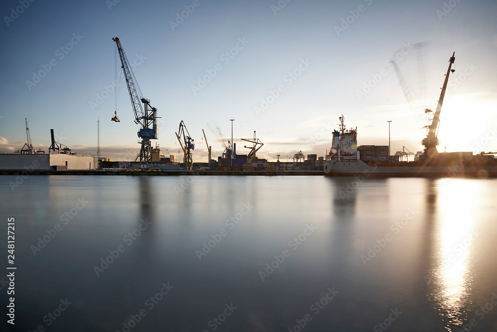 Cranes at work loading and unloading ships at the Port of Rotterdam Cranes at work loading and unloading ships at the Port of Rotterdam