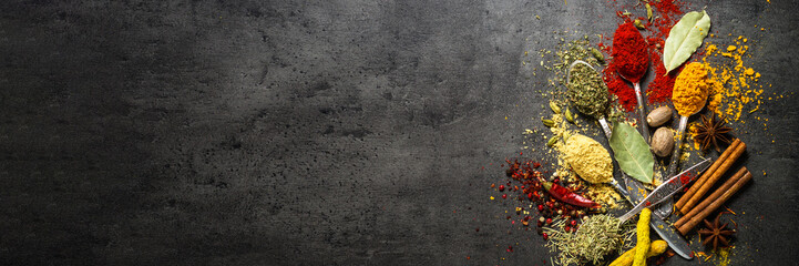 Set of various spices  on black stone background.