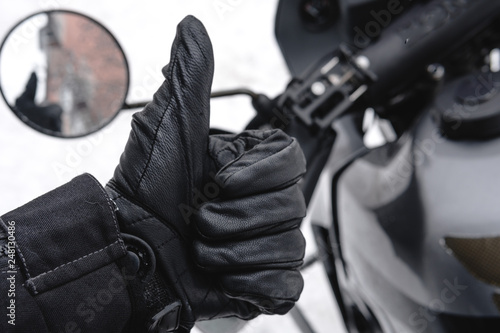 Rider man is like. close up leather gloves. adventure motorcycle on background. Winter fun. snowy day. ride on snow road, active life style concept. winter clothes, equipment, copy spase © Sergey