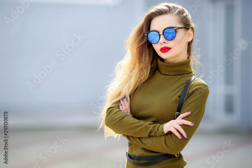 Business Lady in glasses by phone in stylish clothes on the street. © ElenaBatkova
