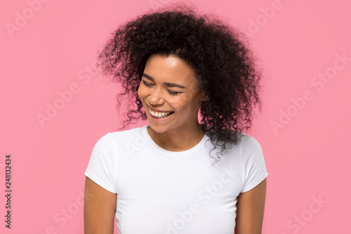 Happy african american girl laughing isolated on pink background