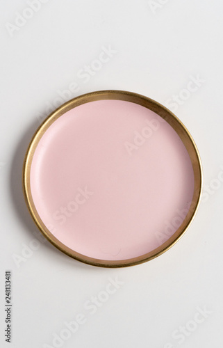 Isolated porcelain pink plate with gold edging on white background. Trendy Living Coral tones. Flat lay, top view.