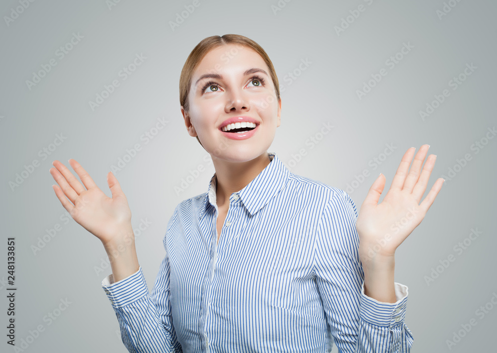 Young woman on white background. Surprised girl looking up, business and education concept Young woman on white background. Surprised girl looking up, business and education concept