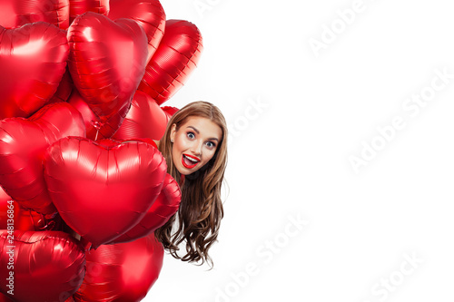 Excited young woman with balloons red heart isolated on white background. Surprised girl. Surprise, valentines people and Valentine's day concept © artmim