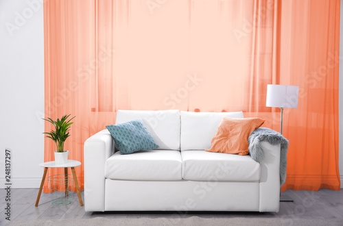 Modern living room interior with comfortable sofa and orange curtains