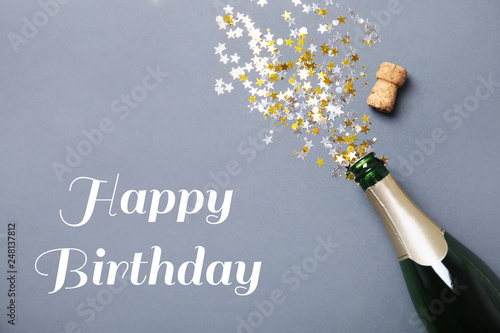 Creative flat lay composition with bottle of champagne and space for text on color background