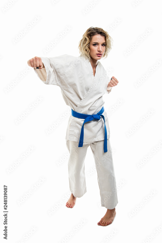 Female wearing martial arts uniform making karate move with fist Female wearing martial arts uniform making karate move with fist