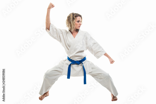 Full body of woman making martial arts pose wearing white outfit