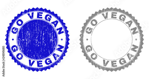 Grunge GO VEGAN stamp seals isolated on a white background. Rosette seals with grunge texture in blue and grey colors. Vector rubber stamp imprint of GO VEGAN label inside round rosette.