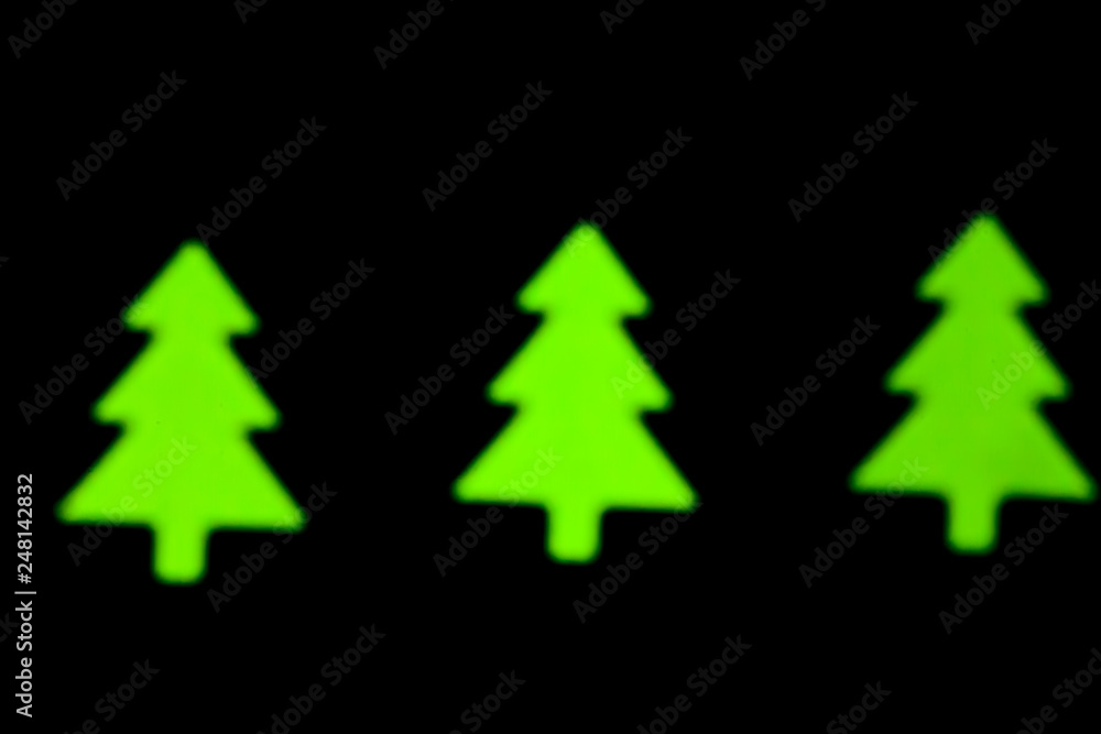 Blurred photo of defocused bokeh colorful lights in the shape of christmas tree