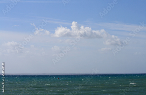 Multicolored sea and clouds in the blue sky © Olga