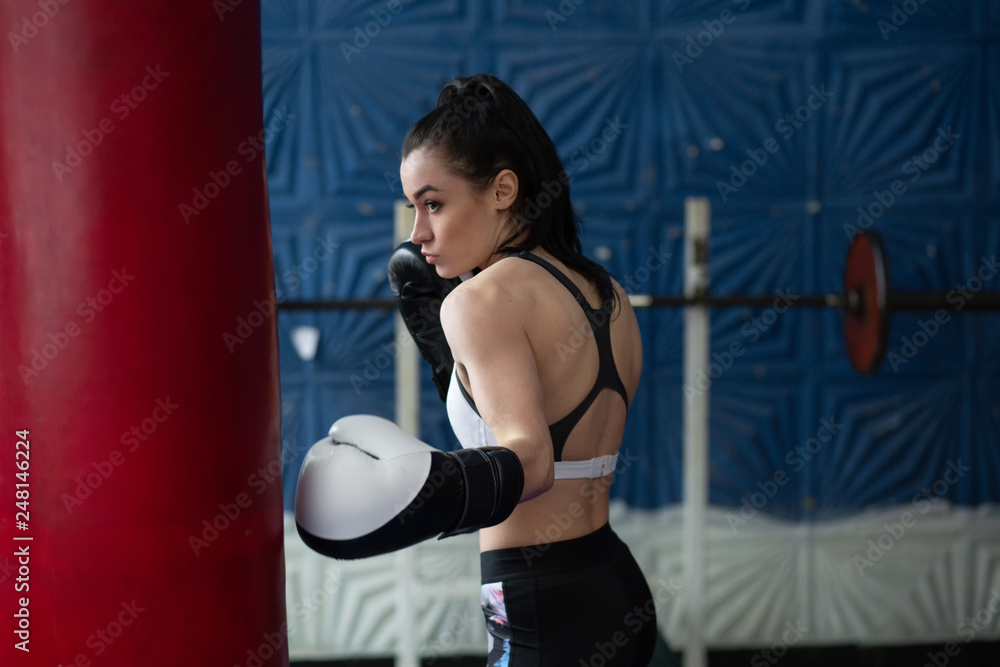 Girl in boxing gloves beats a punch bag Girl in boxing gloves beats a punch bag