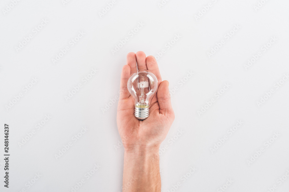 Partial view of man holding bulb on grey background