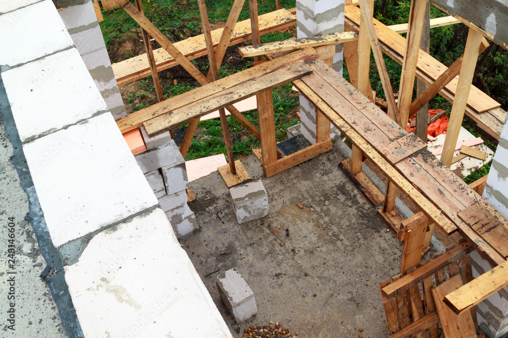 interior of a country house under construction. Site on which the walls are built of gas concrete blocks with wooden formwork interior of a country house under construction. Site on which the walls are built of gas concrete blocks with wooden formwork