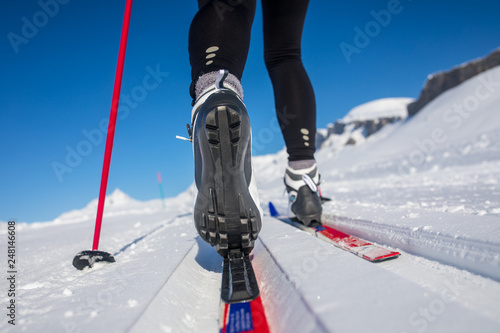 Foto Cross-country skiing: young woman cross-country skiing on a winter day (motion b