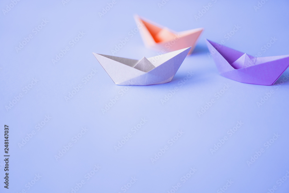 pastel color paper boat on clean background with copy space, learning and education concept pastel color paper boat on clean background with copy space, learning and education concept