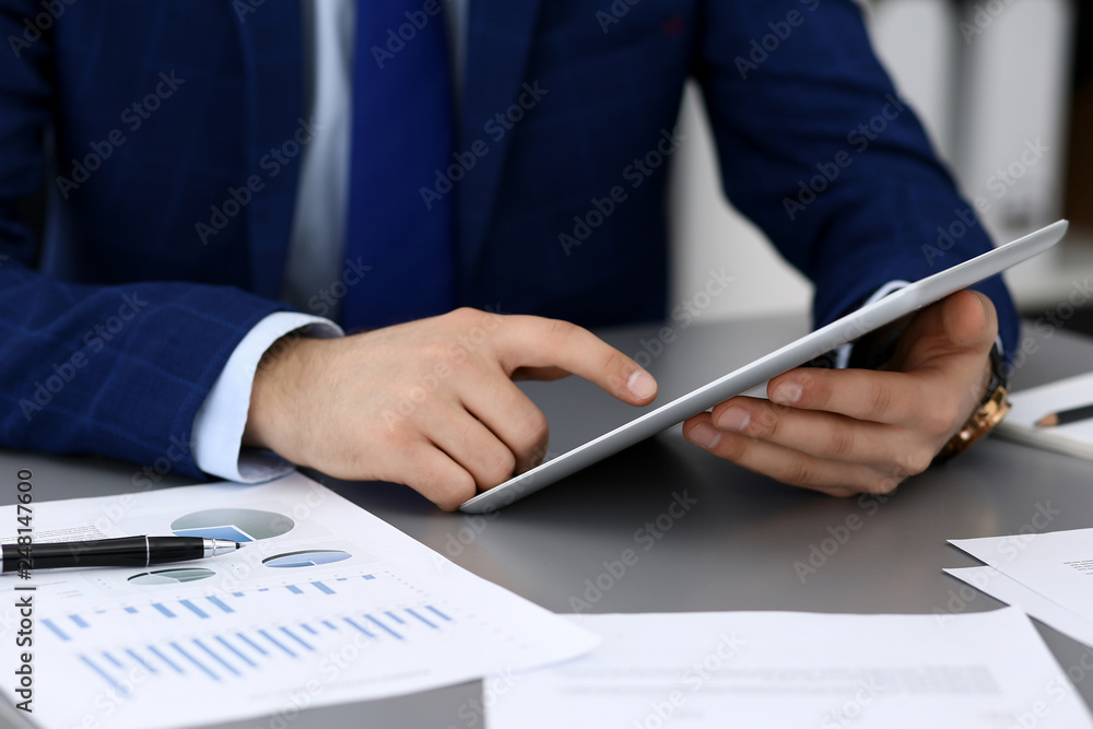 Businessman using tablet at meeting, closeup of hands. Business operations concept Businessman using tablet at meeting, closeup of hands. Business operations concept