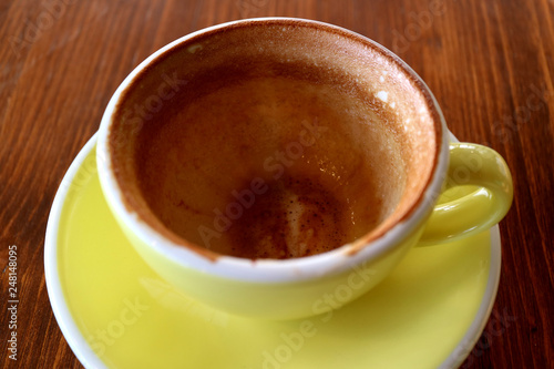 Empty cup of finished drinking cappuccino coffee isolated on wooden table