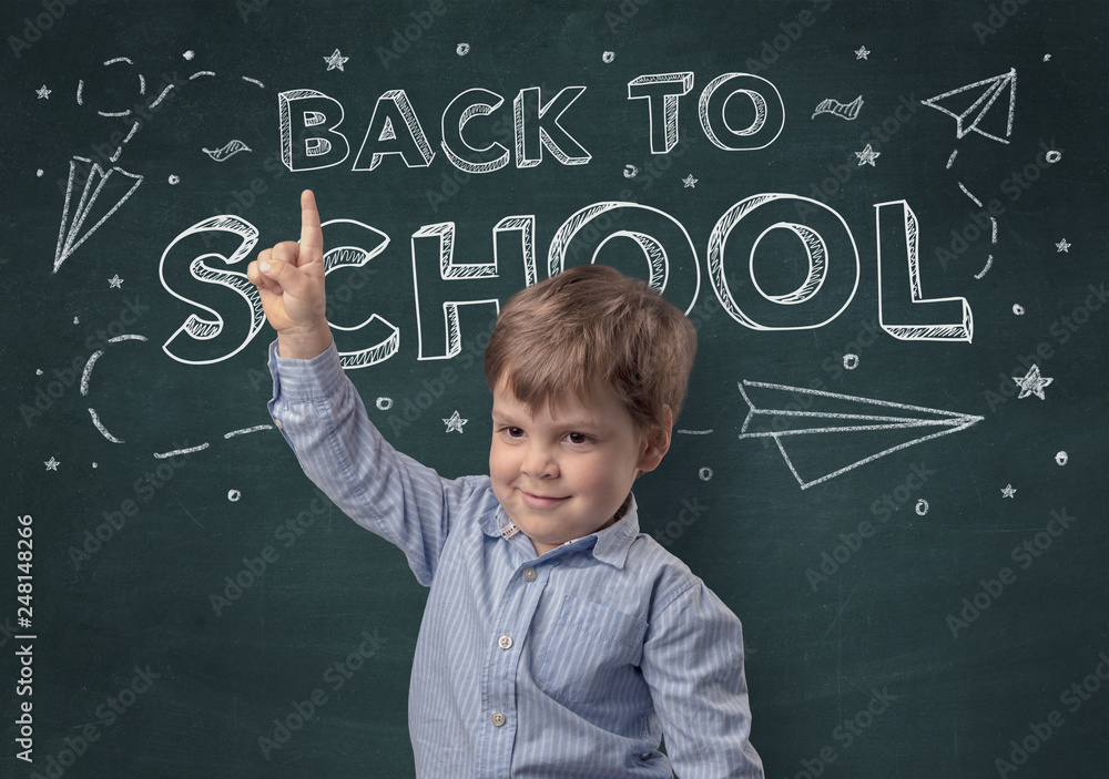 Adorable little boy with blackboard and back to school concept