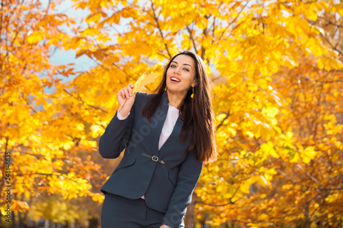 Happy arab businesswoman in blue suit walking in autumn park