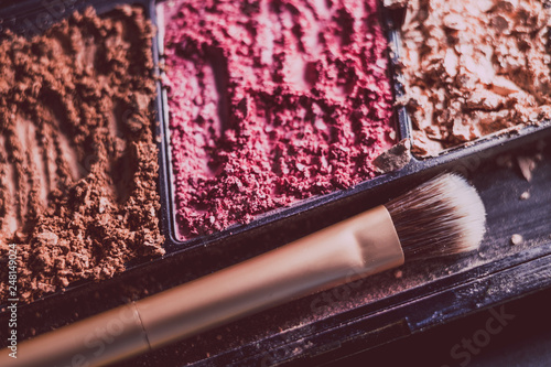 crushed blush and bronzer powders with brush, close-up shot
