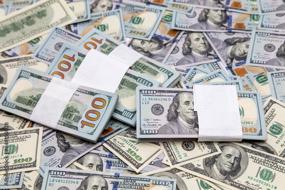 One hundred dollar bills on the table as background One hundred dollar bills on the table as background