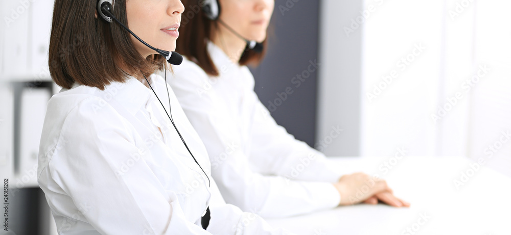 Call center. Group of operators at work. Focus on young brunette woman. Business concept Call center. Group of operators at work. Focus on young brunette woman. Business concept