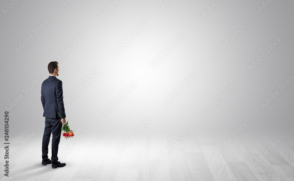 Man standing with his back in an empty room with object in his hand Man standing with his back in an empty room with object in his hand