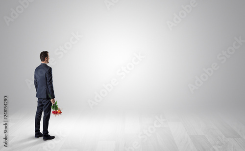 Man standing with his back in an empty room with object in his hand