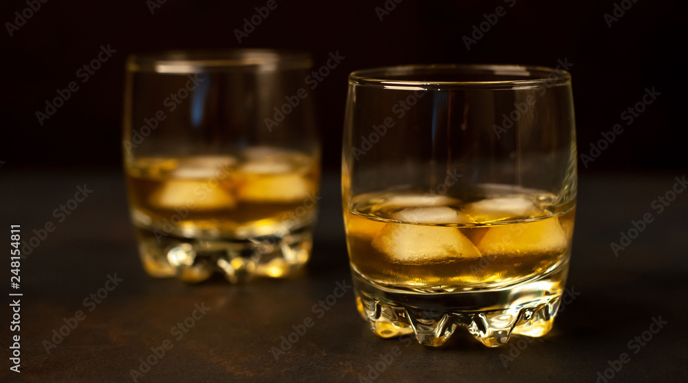 two glasses of whiskey with ice on the concrete two glasses of whiskey with ice on the concrete