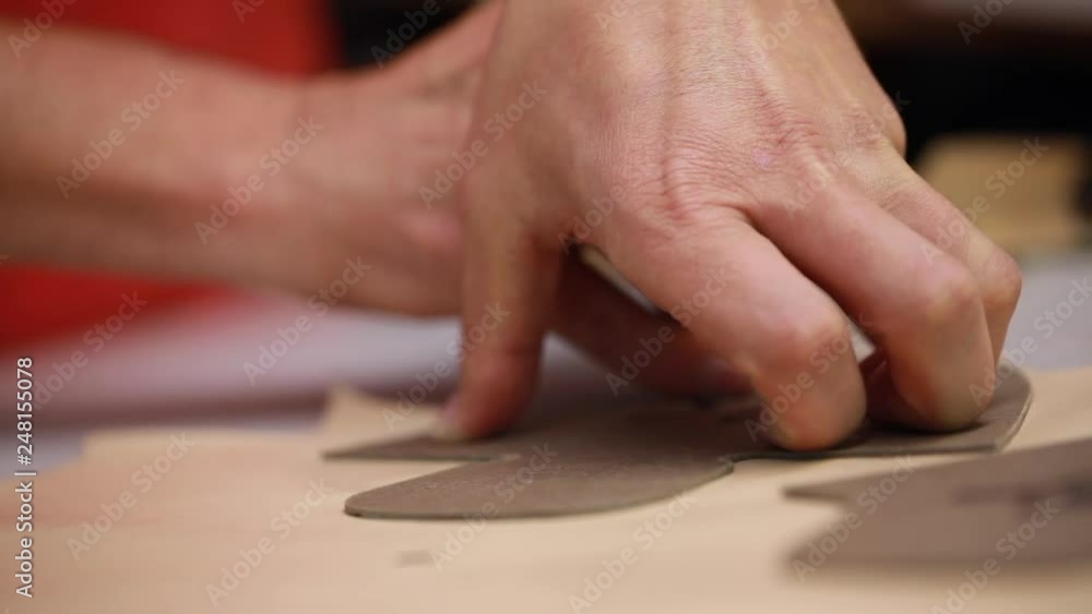 Shoes designing and preparing the pattern for the shoe parts before assembly on workshop for making shows artisan handmade manufacturing leather shoes Shoes designing and preparing the pattern for the shoe parts before assembly on workshop for making shows artisan handmade manufacturing leather shoes