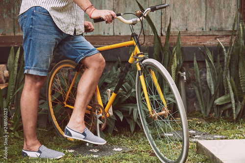 Attractive man standing with old bicycle.