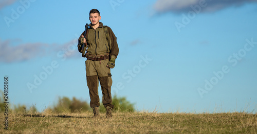 Guy hunting nature environment. Hunting weapon gun or rifle. Hunting hobby. Masculine hobby activity. Man hunter carry rifle blue sky background. Experience and practice lends success hunting