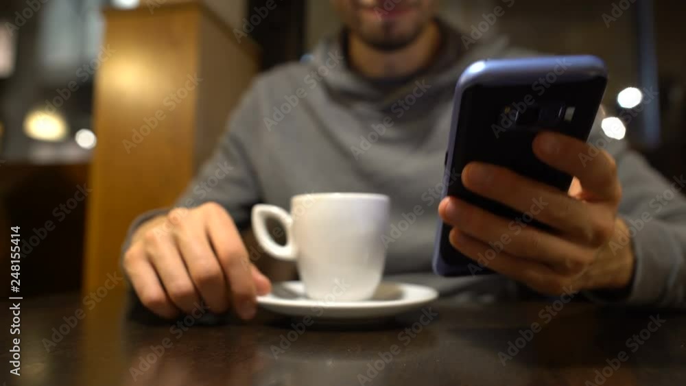 Upset man sitting in cafe and using smartphone, reading bad news massage sadness Upset man sitting in cafe and using smartphone, reading bad news massage sadness