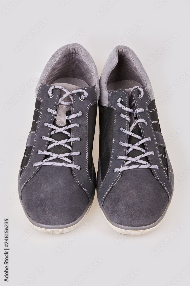 Pair of new modern grey stylish sneakers for men isolated on white background Pair of new modern grey stylish sneakers for men isolated on white background