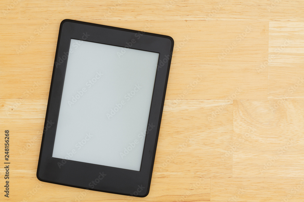 An e-reader on a wood desk An e-reader on a wood desk