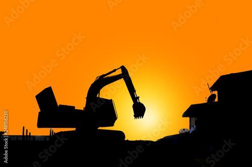 silhouette of Industrial excavator working on construction site to clear the land of sand and soil photo