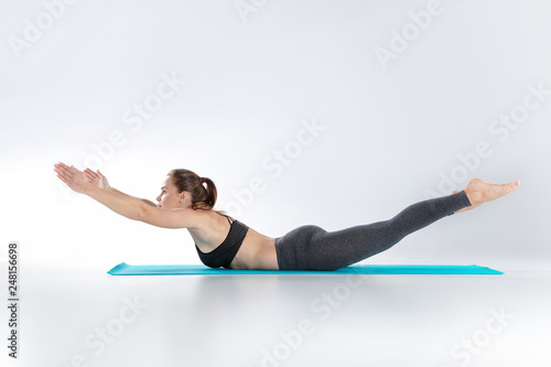 Beautiful woman doing sport exercises on mat