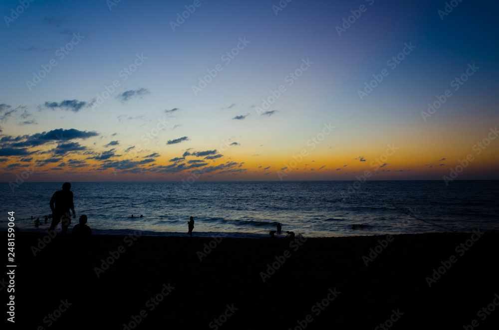 Enjoying calm peaceful sunset at the asia pacific tropical beach with family and friends with blue water Enjoying calm peaceful sunset at the asia pacific tropical beach with family and friends with blue water