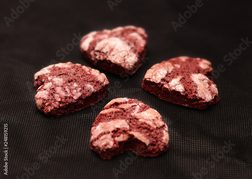 red chocolate cracked heart-shaped cookies on on a dark background. A gift for Valentine's Day, World Women's Day or Birthday