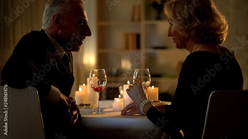 Senior woman and man flirting in restaurant, love feelings, aged couple romance