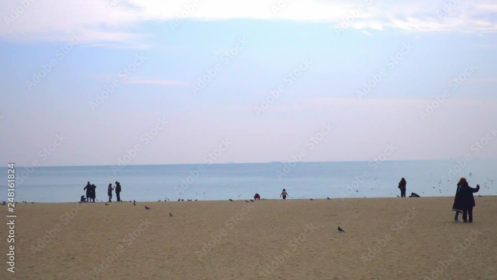 Busan, South Korea/ December 26,2018 - view of beautiful Haeundae beach and tourist visiting the beach Busan, South Korea/ December 26,2018 - view of beautiful Haeundae beach and tourist visiting the beach