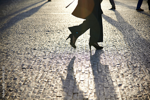 Silhouettes of business people walking down a cobble stone street in the business district