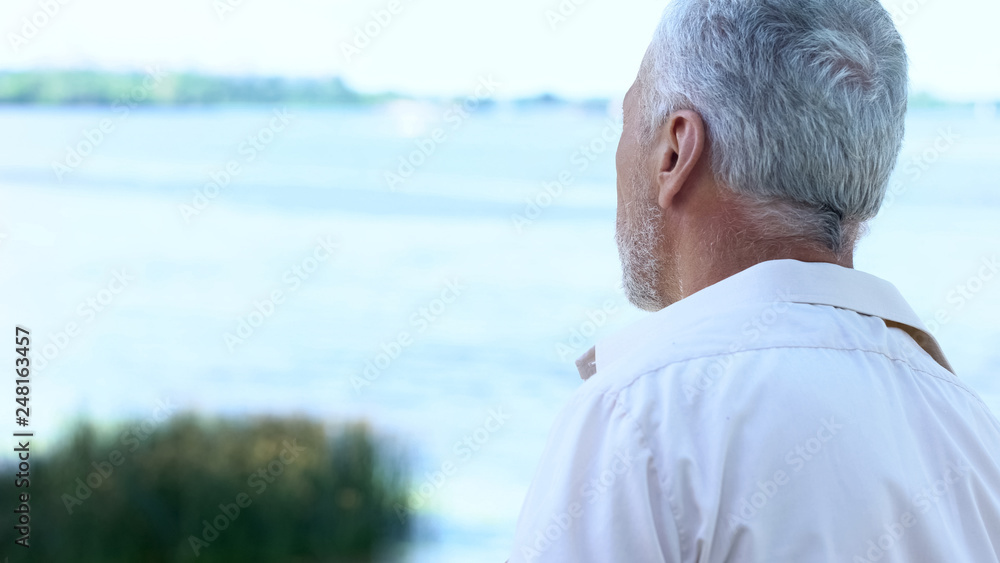 Back view of senior man looking at river and beautiful landscape, tourism Back view of senior man looking at river and beautiful landscape, tourism