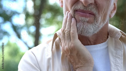 Dental pain, retired man suffering from toothache, teeth prosthetics, dentistry