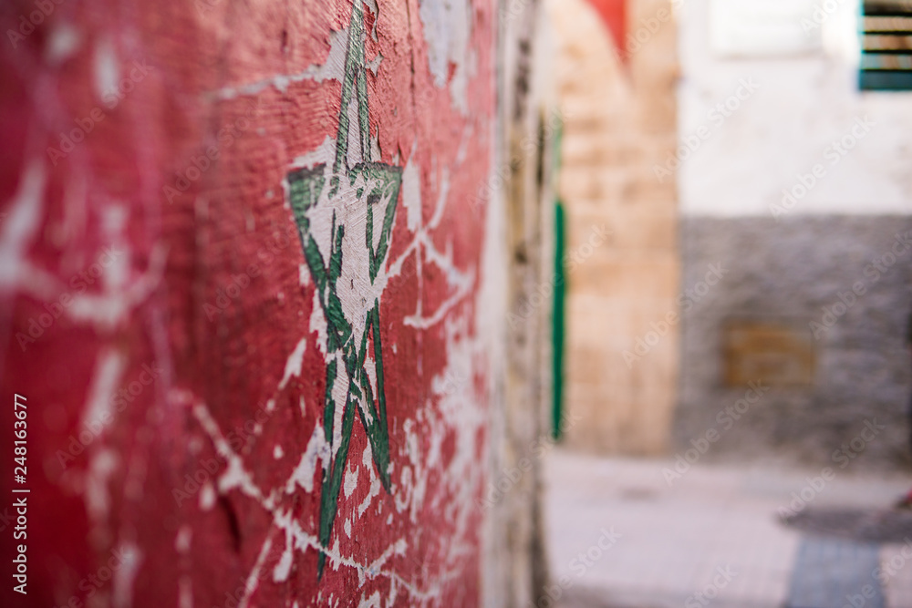 Green star flag of Morocco on street wall in Essaouira Medina