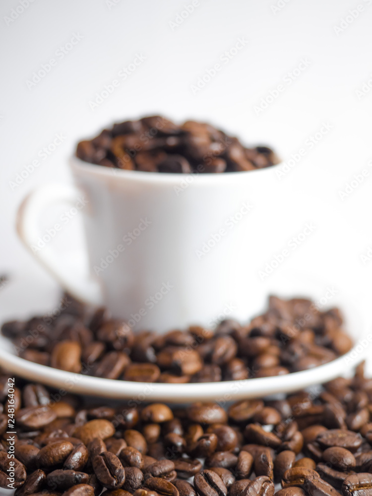 Coffee beans in coffee cup isolated on white Coffee beans in coffee cup isolated on white