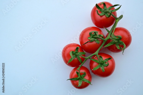 fresh tomatoes on a blue  background © Moralli