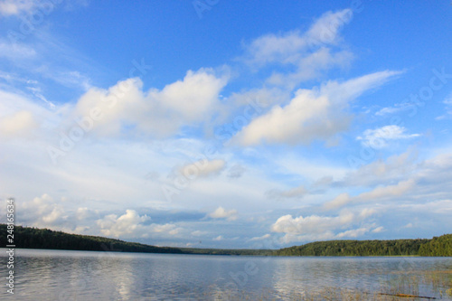 Blue sky with light clouds on a Sunny day  light ripples on the water surface